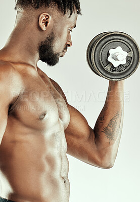 Buy stock photo Cropped shot of a muscular young man lifting dumbbells