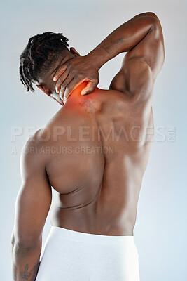 Buy stock photo Studio shot of a muscular young man experiencing discomfort in his neck