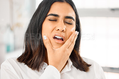 Buy stock photo Shot of a young woman suffering from toothache at home