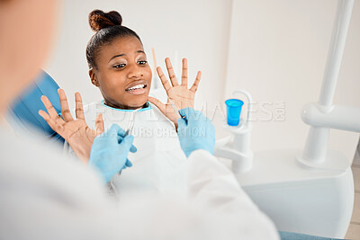 Buy stock photo Shot of a young woman looking afraid at the dentists office