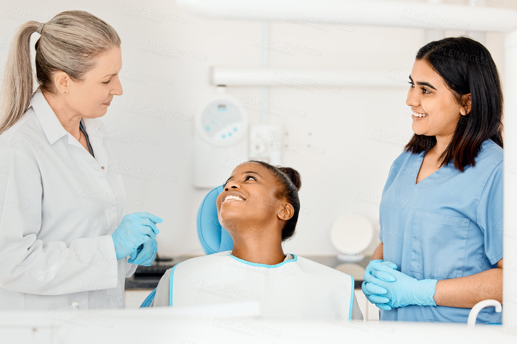 Buy stock photo Shot of a dentist and her nurse treating a patient