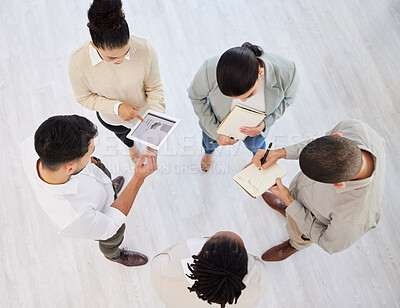 Buy stock photo High angle shot of a young and diverse group of businesspeople standing in a circle in their workplace