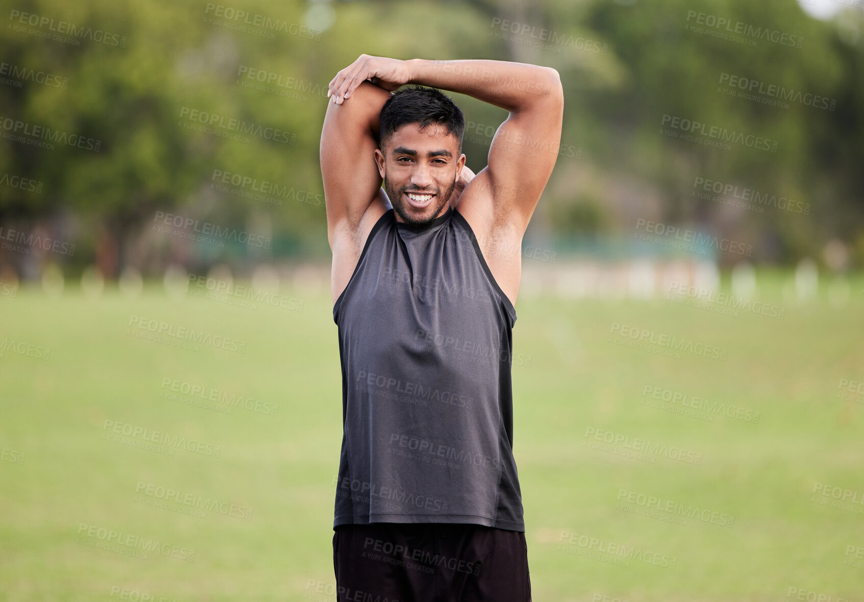 Buy stock photo Shot of a handsome young man  stretching before his outdoor run