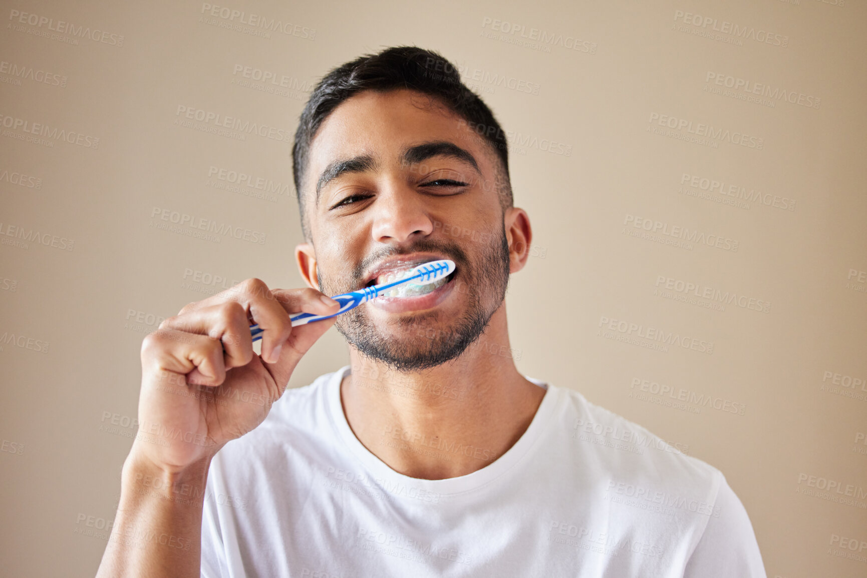 Buy stock photo Studio shot of a handsome young man brushing his teeth against a studio background