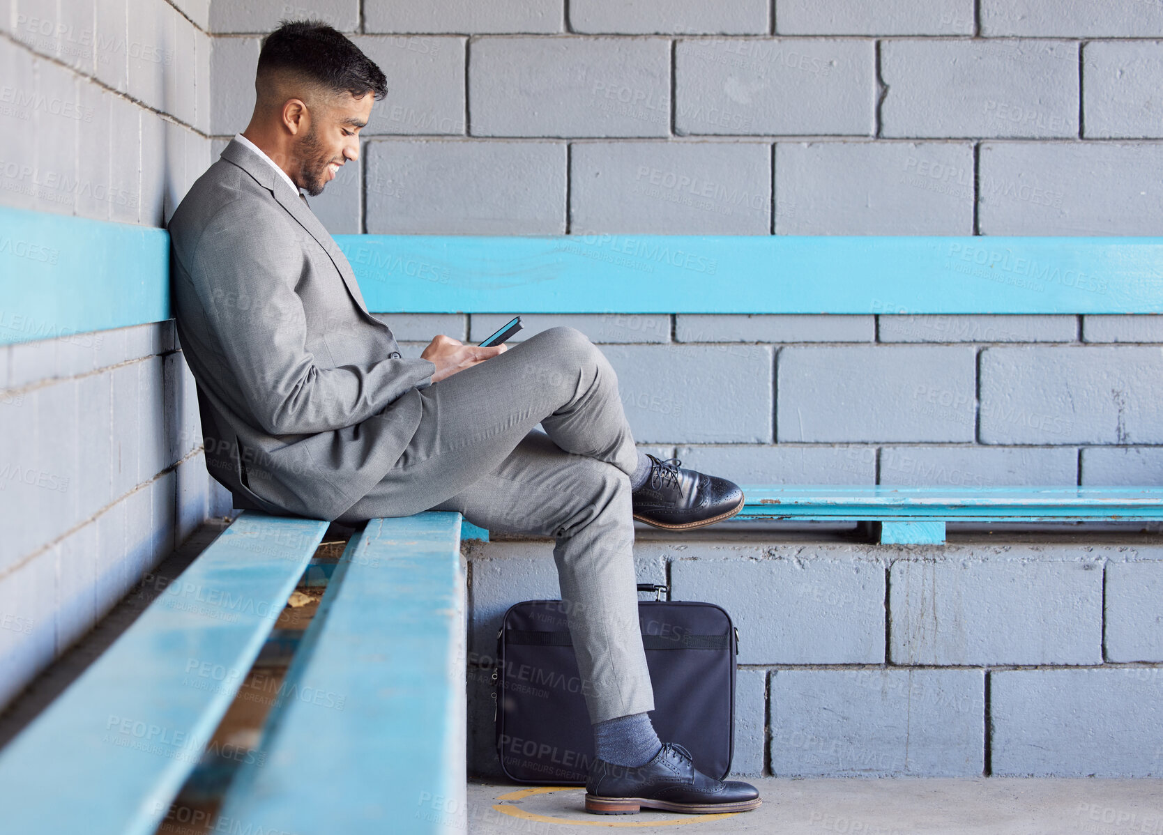 Buy stock photo Business man, phone and bench at station for travel, check train schedule and browse on app in outdoors. Male person, relax and employee for commute to work, typing and internet for ticket website