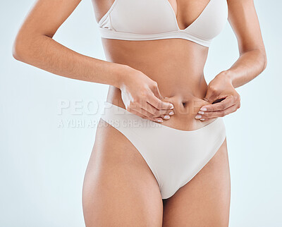 Buy stock photo Woman, pinch abdomen and underwear in studio, detox and results of aesthetic on white background. Female person, liposuction and confident for bodycare or weight loss, fat and lingerie for tummy tuck