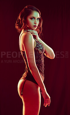 Buy stock photo Cropped portrait of a beautiful young woman posing in lingerie against a red background
