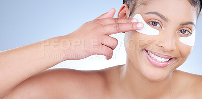 Buy stock photo Studio portrait of an attractive young woman wearing an under eye patch against a blue background