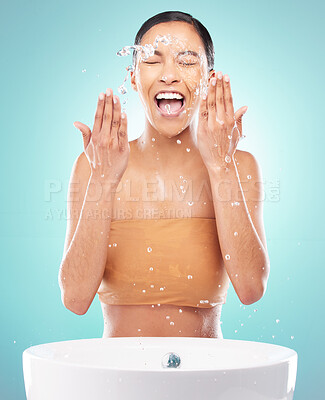 Buy stock photo Shot of a young woman doing her daily skincare routine against a blue background