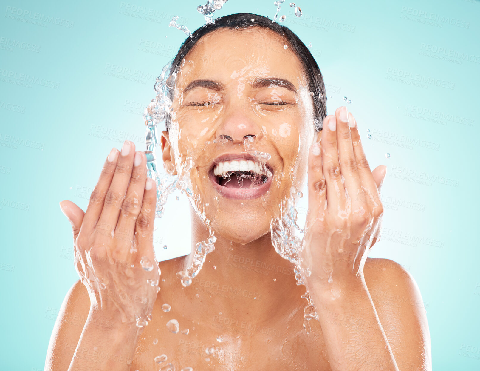 Buy stock photo Skincare, water and woman washing face in studio for wellness, hygiene and health isolated on blue background. Beauty, cleaning and excited model splash liquid for dermatology and shower in bathroom