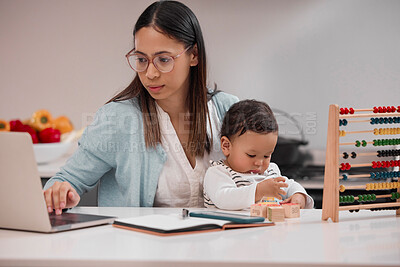 Buy stock photo Shot of a young mother working from home while holding her baby