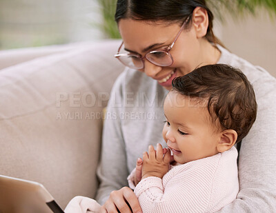 Buy stock photo Shot of a mother using a tablet with her baby at home