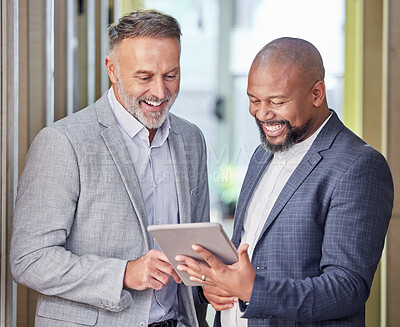 Buy stock photo Shot of two businessmen working together while using a digital tablet