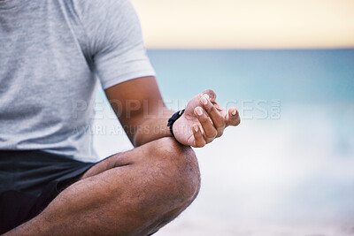 Buy stock photo Cropped shot of an unrecognizable male athlete meditating on the beach