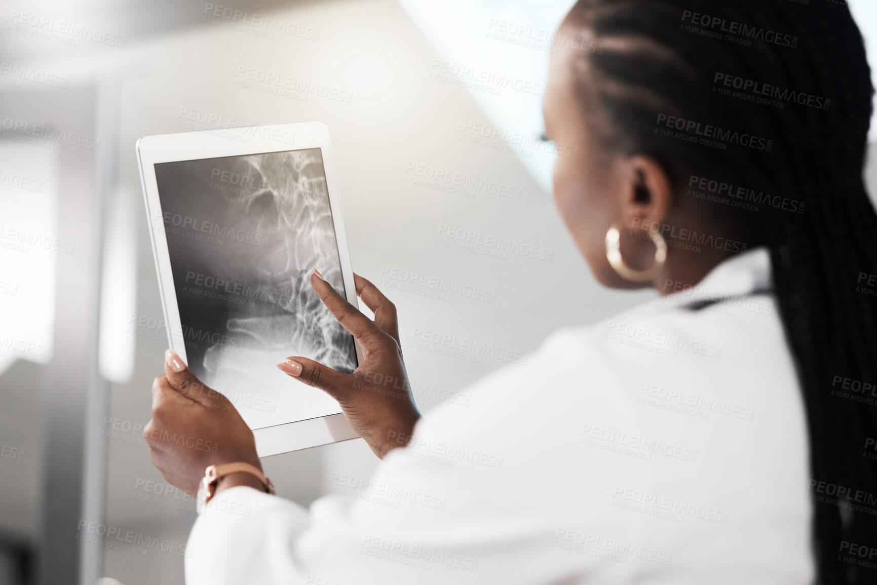 Buy stock photo Shot of a doctor analysing an x ray on the screen of a digital tablet