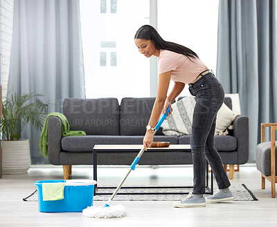 Buy stock photo Full length shot of an attractive young woman mopping the floor while cleaning her home