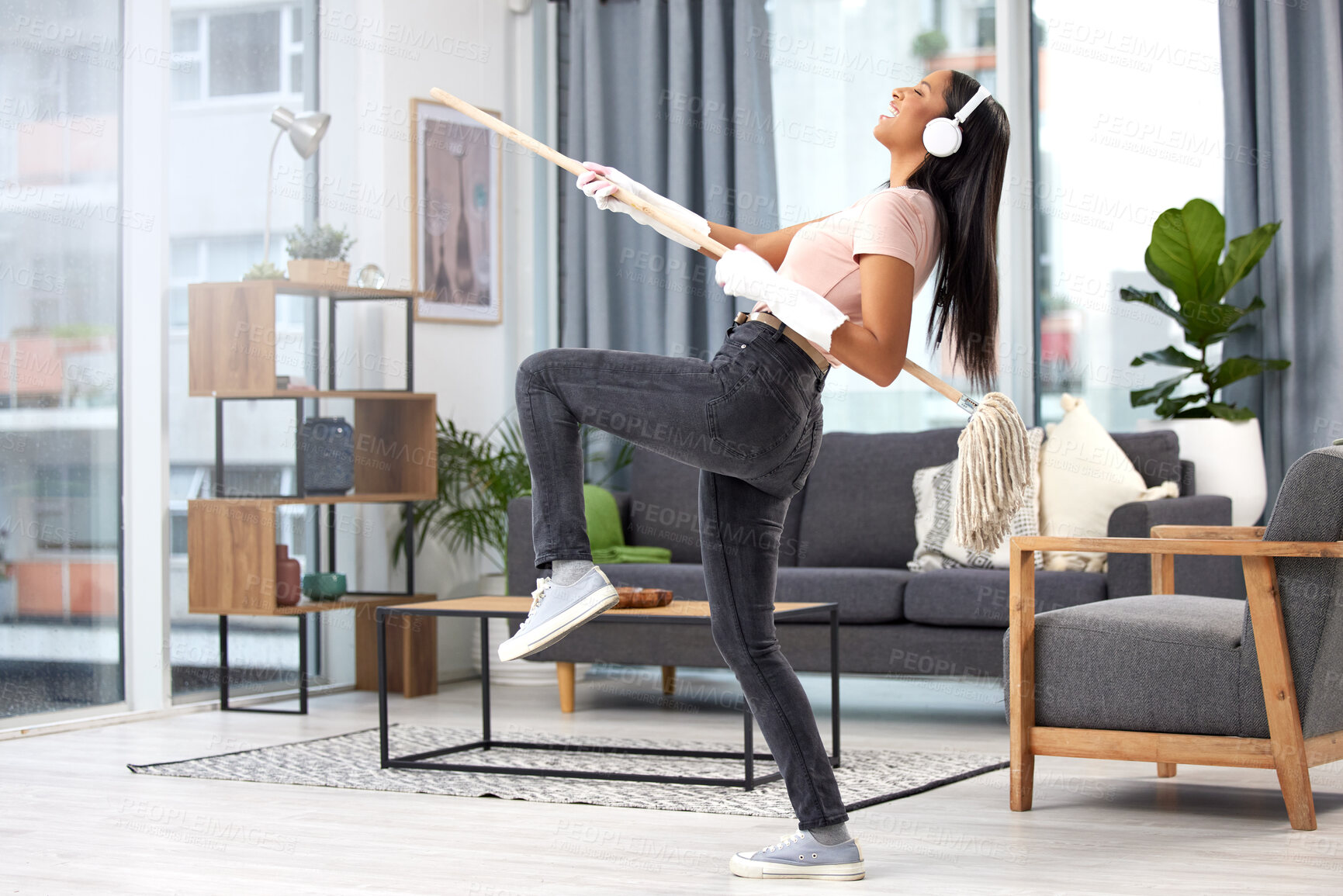 Buy stock photo Full length shot of an attractive young woman having fun while cleaning her home