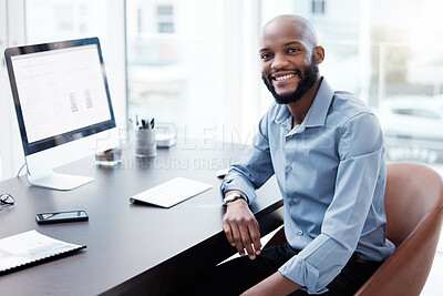 Buy stock photo Cropped portrait of a handsome young businessman working on his computer in the office