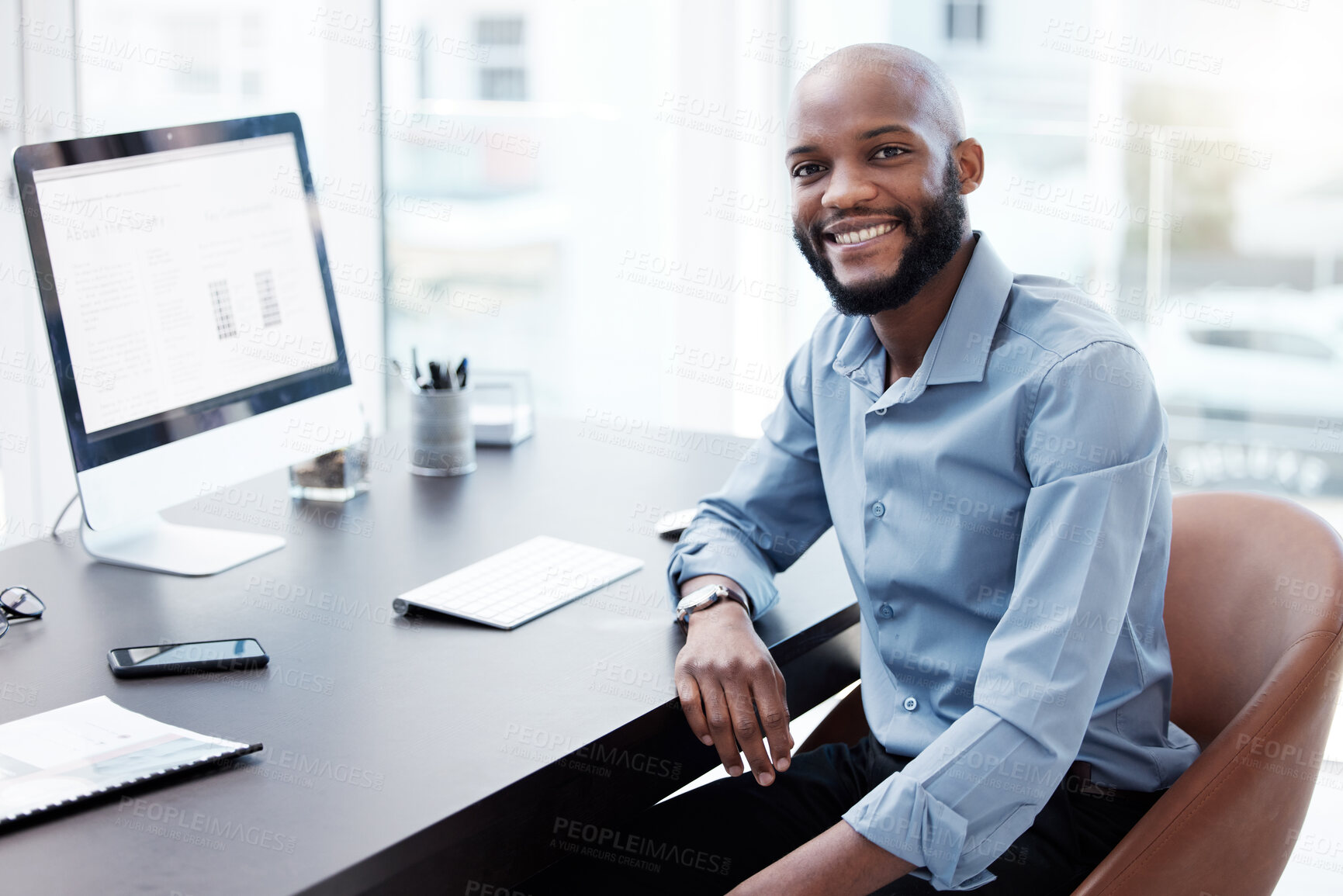 Buy stock photo Cropped portrait of a handsome young businessman working on his computer in the office