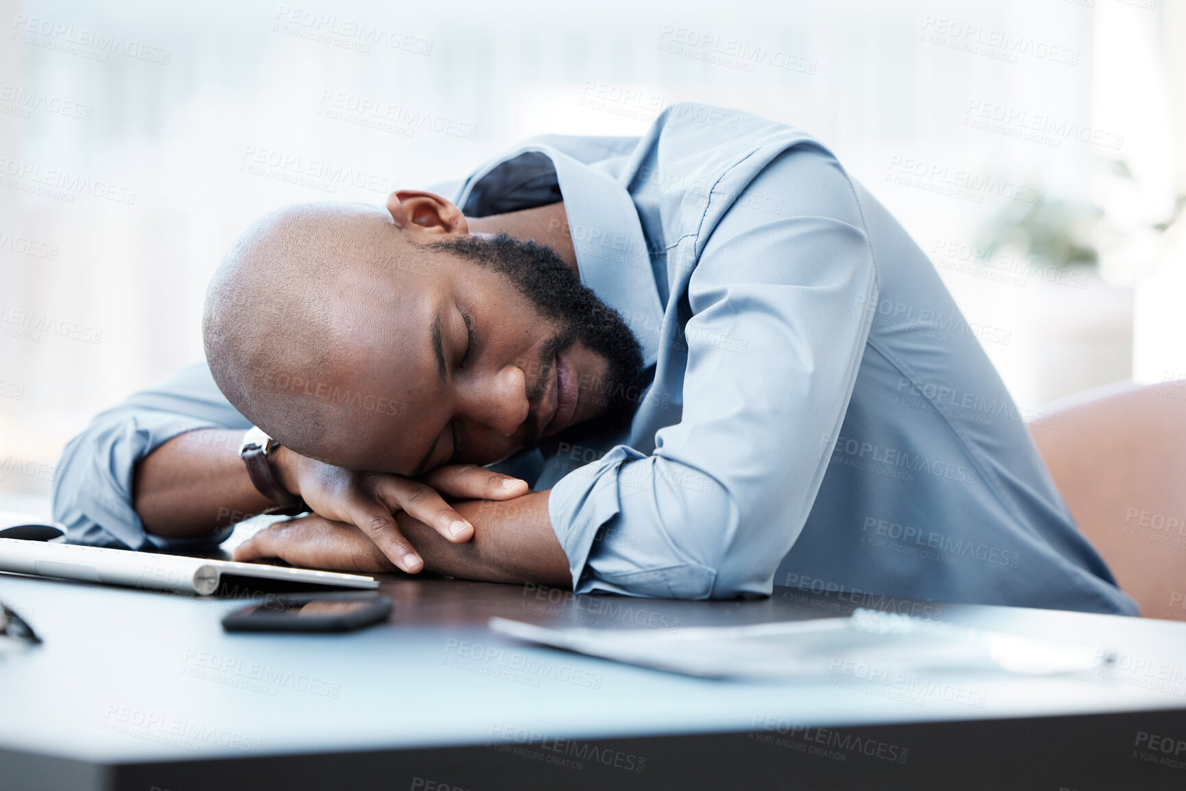 Buy stock photo Cropped shot of a handsome young businessman sleeping on his desk in the office