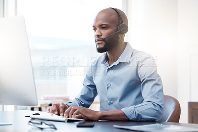 Buy stock photo Cropped shot of a handsome young male call center agent working on his computer in the office