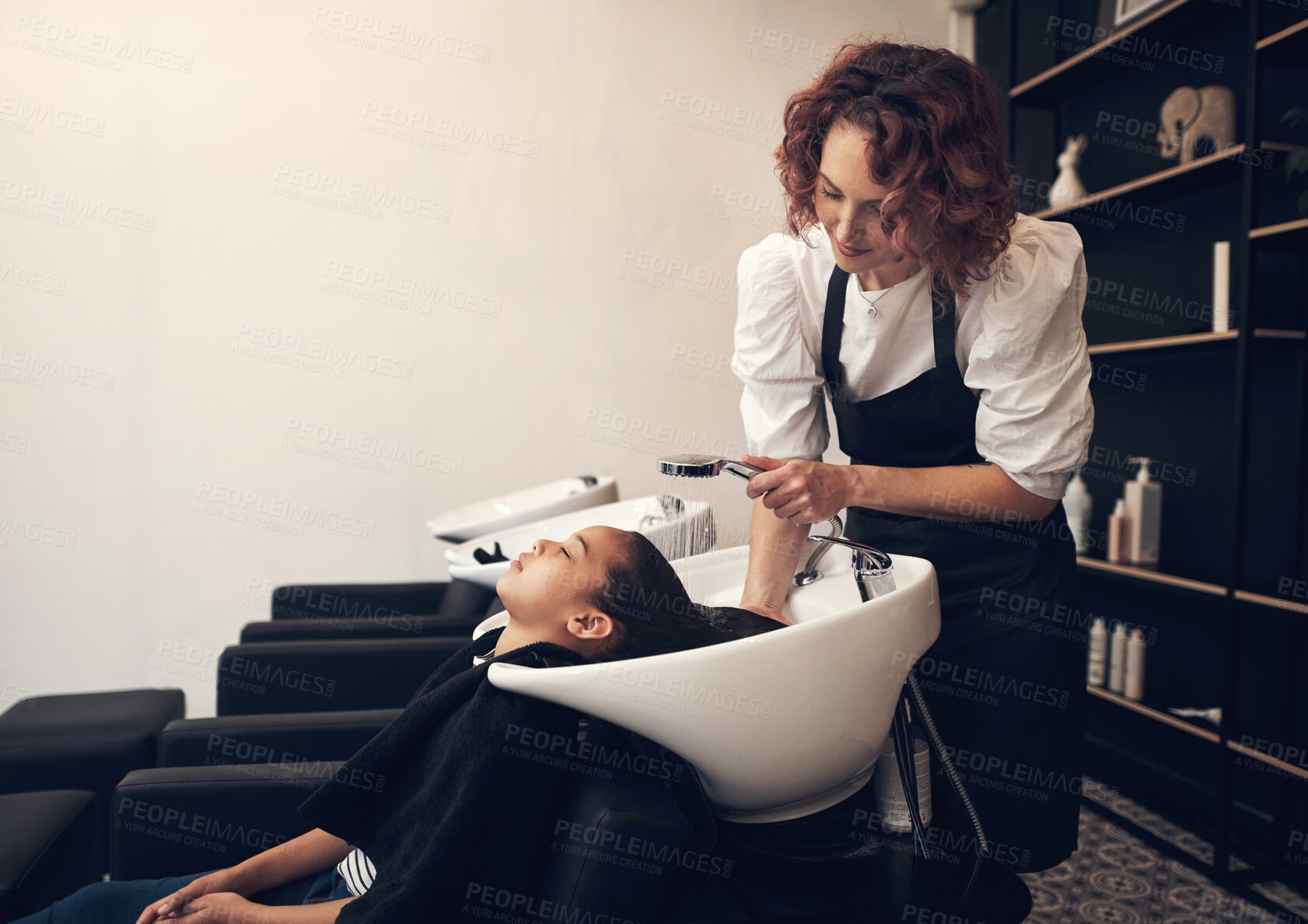 Buy stock photo Shot of a young girl getting her hair washed at the salon