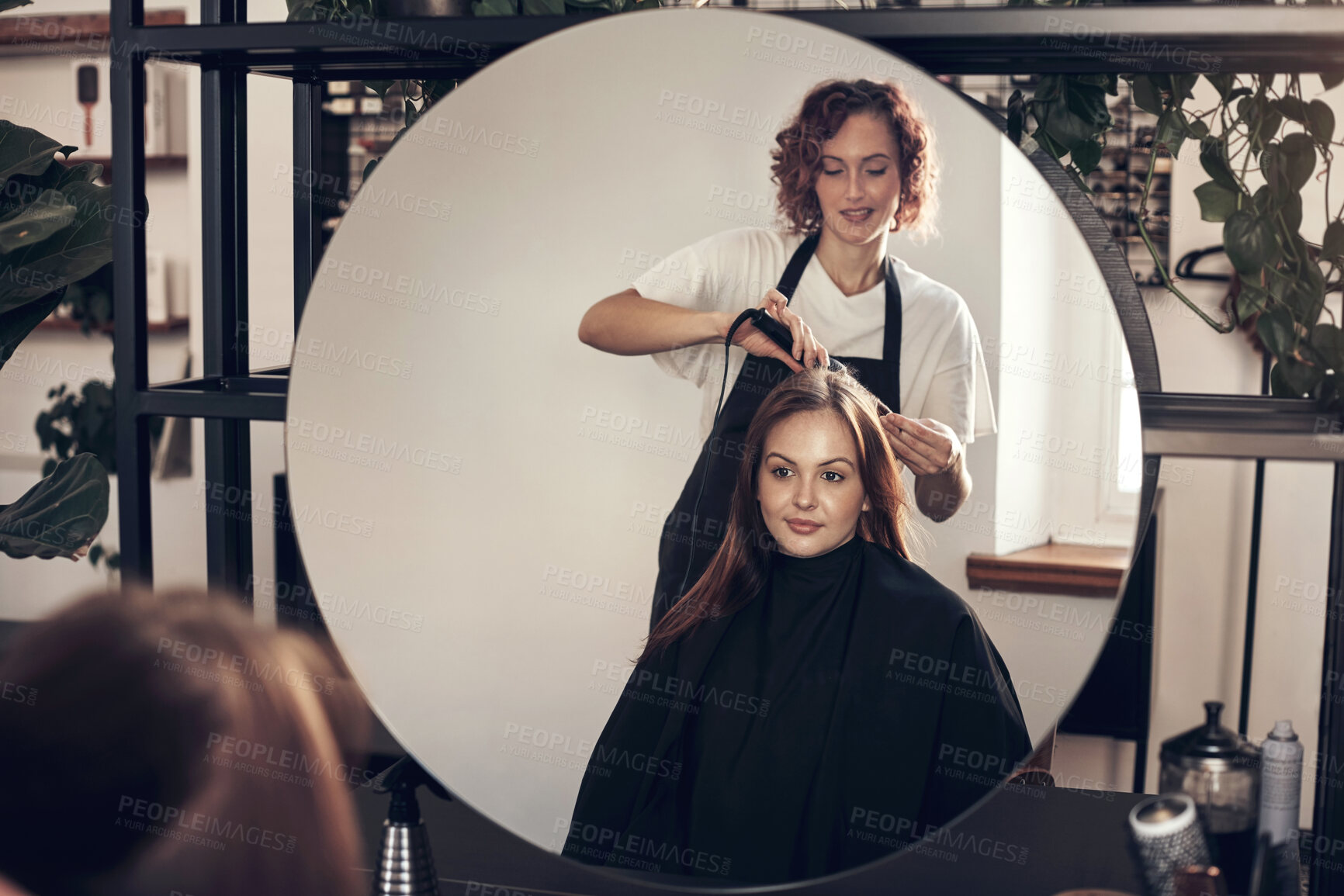 Buy stock photo Hairdresser, woman and client with tool for heat treatment, maintenance and haircare of curling style. People, designer and mirror reflection for consultation, blowout and change at luxury salon