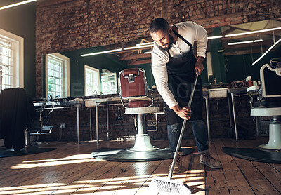 Buy stock photo Barber, salon and man with broom for cleaning after grooming, shaving and hair cut for beauty service. Hygiene, workplace and hairdresser in barbershop sweeping for dirt, dust and mess on floor