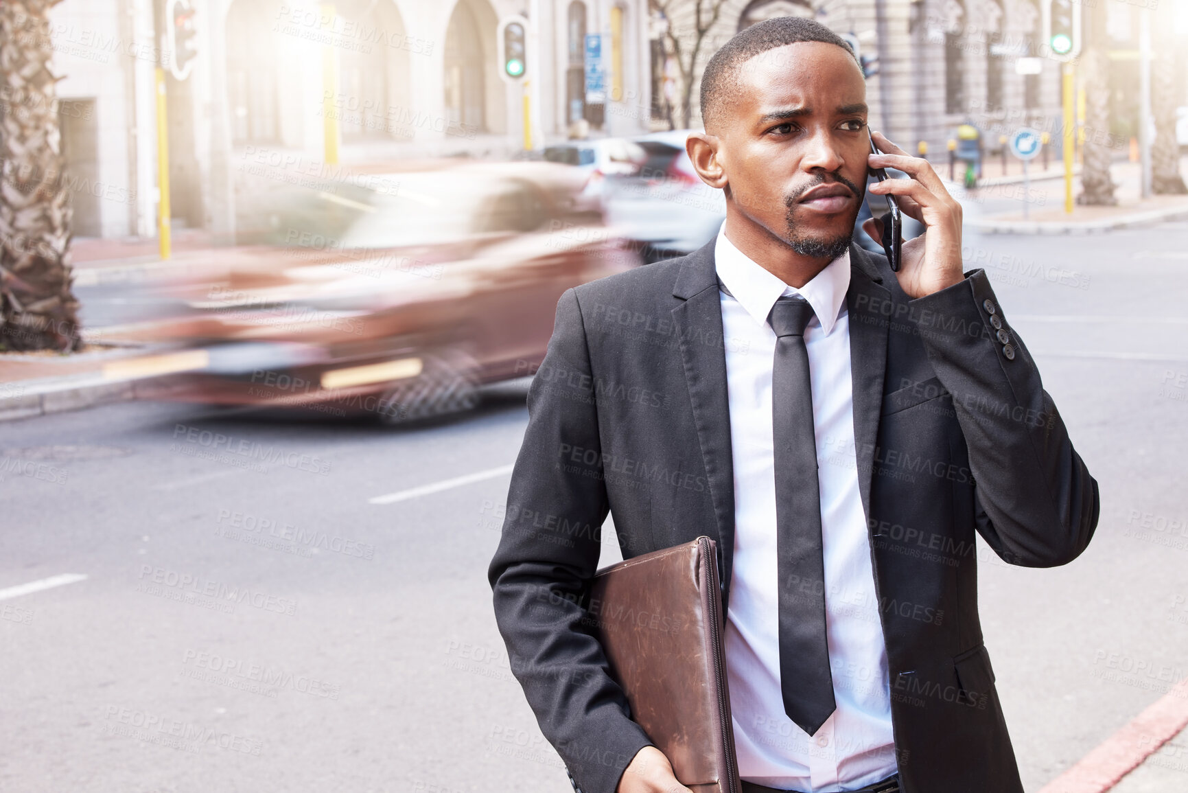 Buy stock photo Serious, businessman and phone call for networking, conversation and communication on commute. Confident, black man and portfolio with smartphone for talking with lens flare outside on urban street