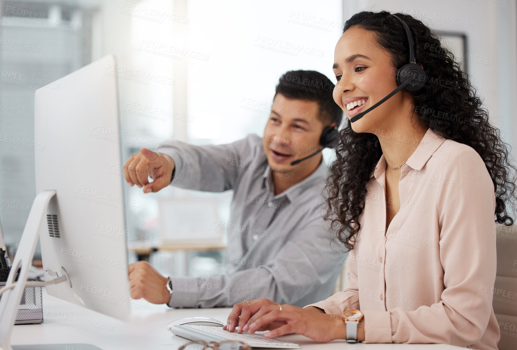 Buy stock photo Shot of two call centre agents working together on a computer in an office