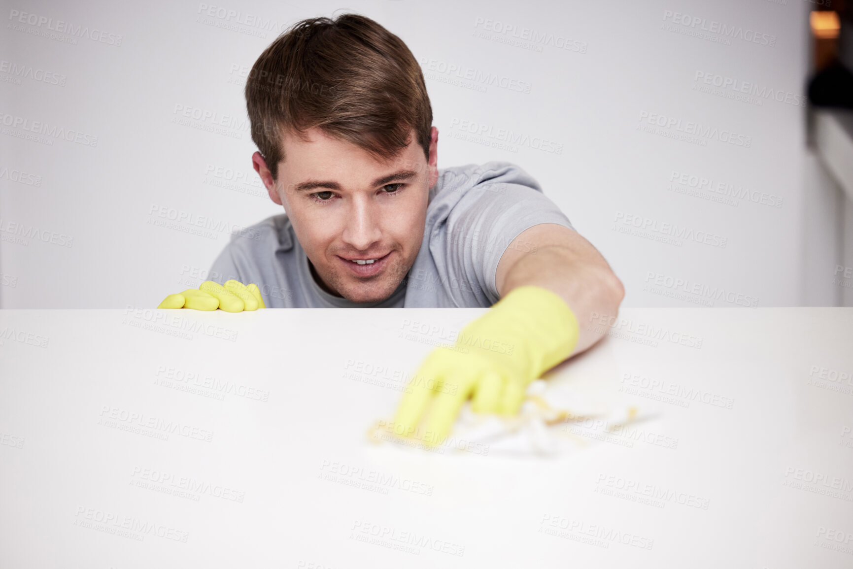 Buy stock photo Man, clean and home and kitchen counter, happy and wipe with cloth or disinfectant cleaner for germs maintenance. Apartment, housework and health safety, hygiene and glove for bacteria protection