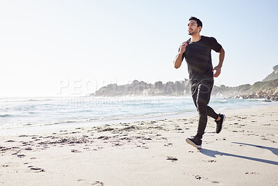 Buy stock photo Full length shot of a handsome young male athlete out for a run on the beach