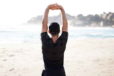 Buy stock photo Rearview shot of an unrecognizable young man stretching before his workout on the beach