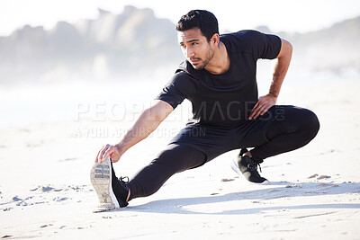 Buy stock photo Full length shot of a handsome young male athlete warming up before his workout on the beach