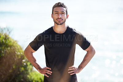 Buy stock photo Cropped portrait of a handsome young male athlete standing with his hands on his hips outside