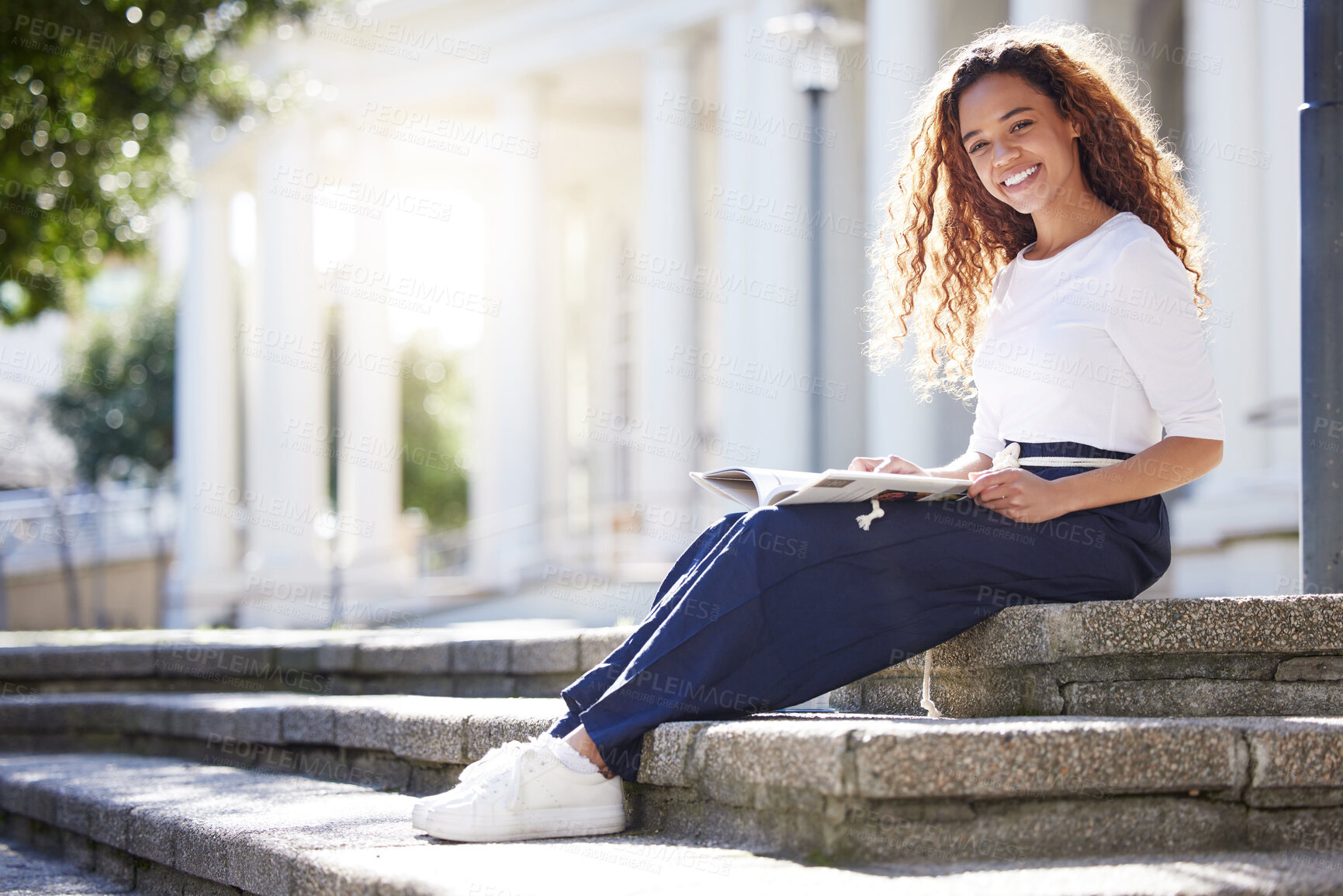 Buy stock photo Shot of a young woman reading a book outside at campus