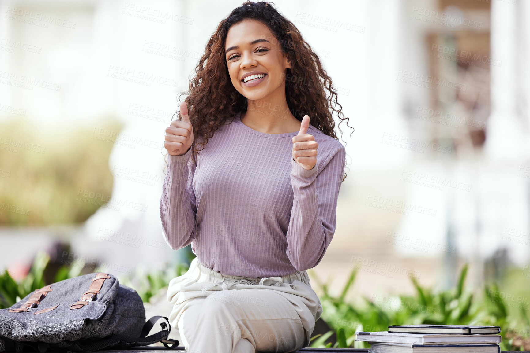 Buy stock photo Shot of a young woman showing a thumbs up while sitting in a park
