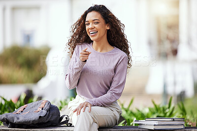 Buy stock photo Shot of a young woman pointing her finger while sitting in a park