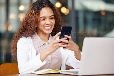 Buy stock photo Shot of a young woman using a phone and laptop while working at a cafe