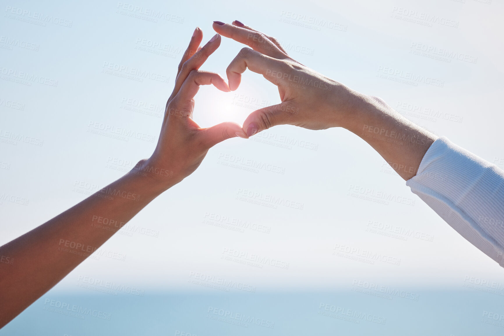 Buy stock photo Friends, hand and heart sign by the ocean with love, trust and emoji gesture outdoor on holiday. Support, care and sunshine with people showing with happy shape by the sea and beach water together