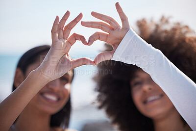Buy stock photo Friends, closeup and heart hands with women at beach for summer, happy and teamwork. Support, freedom and love with people and holding shape in outdoors for collaboration, faith and community gesture