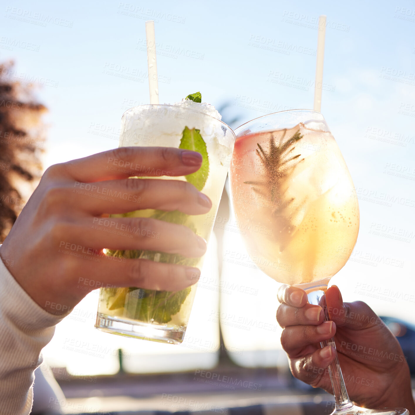 Buy stock photo Shot of two female friends celebrating with drinks at a bar outside