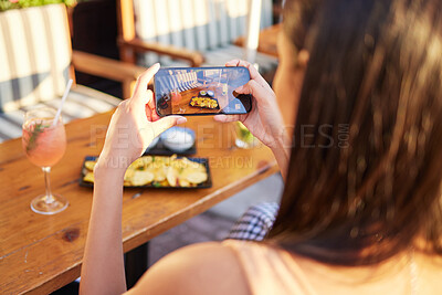 Buy stock photo Rearview shot of an unrecognizable woman talking a picture of her meal at a restaurant outside