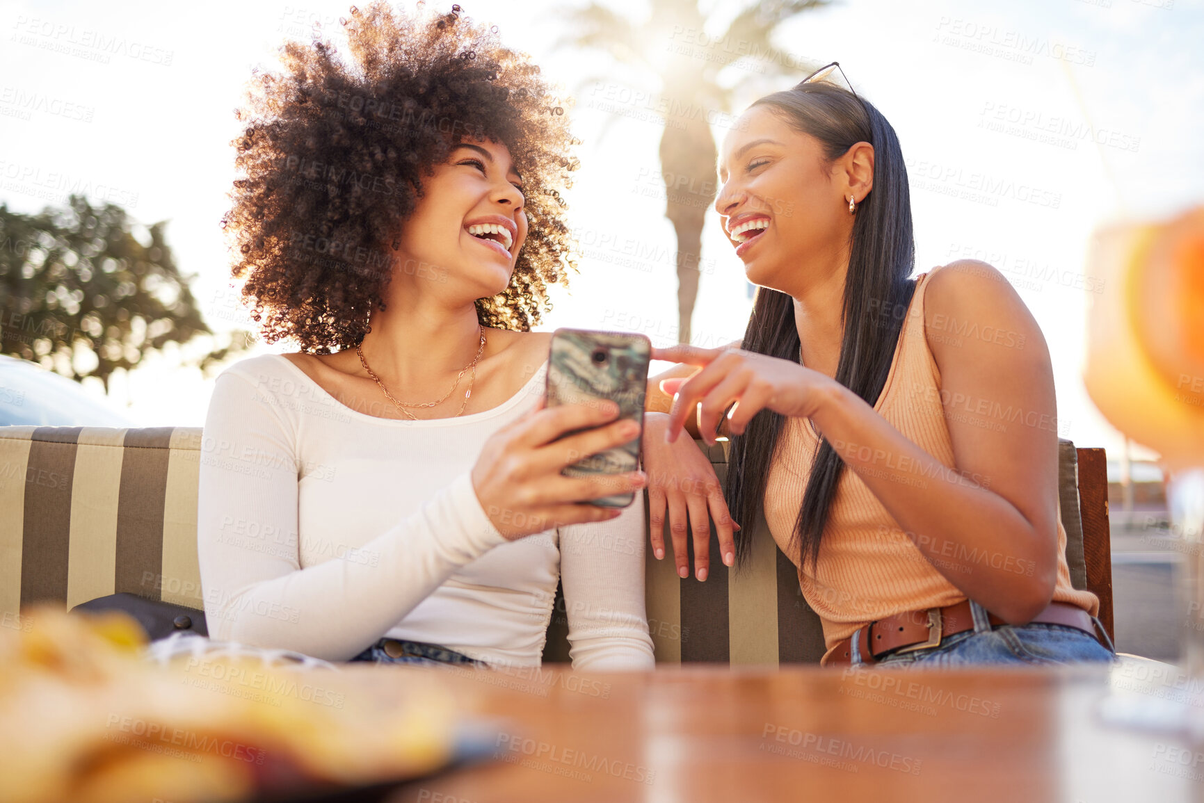 Buy stock photo Laughing, happy and women with a phone at a cafe for a meme or social media notification. Smile, talking and friends with a mobile for a funny app, comic conversation or comedy together at restaurant