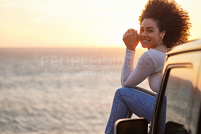 Buy stock photo Portrait of a young woman enjoying the fresh beach air while the sun sets