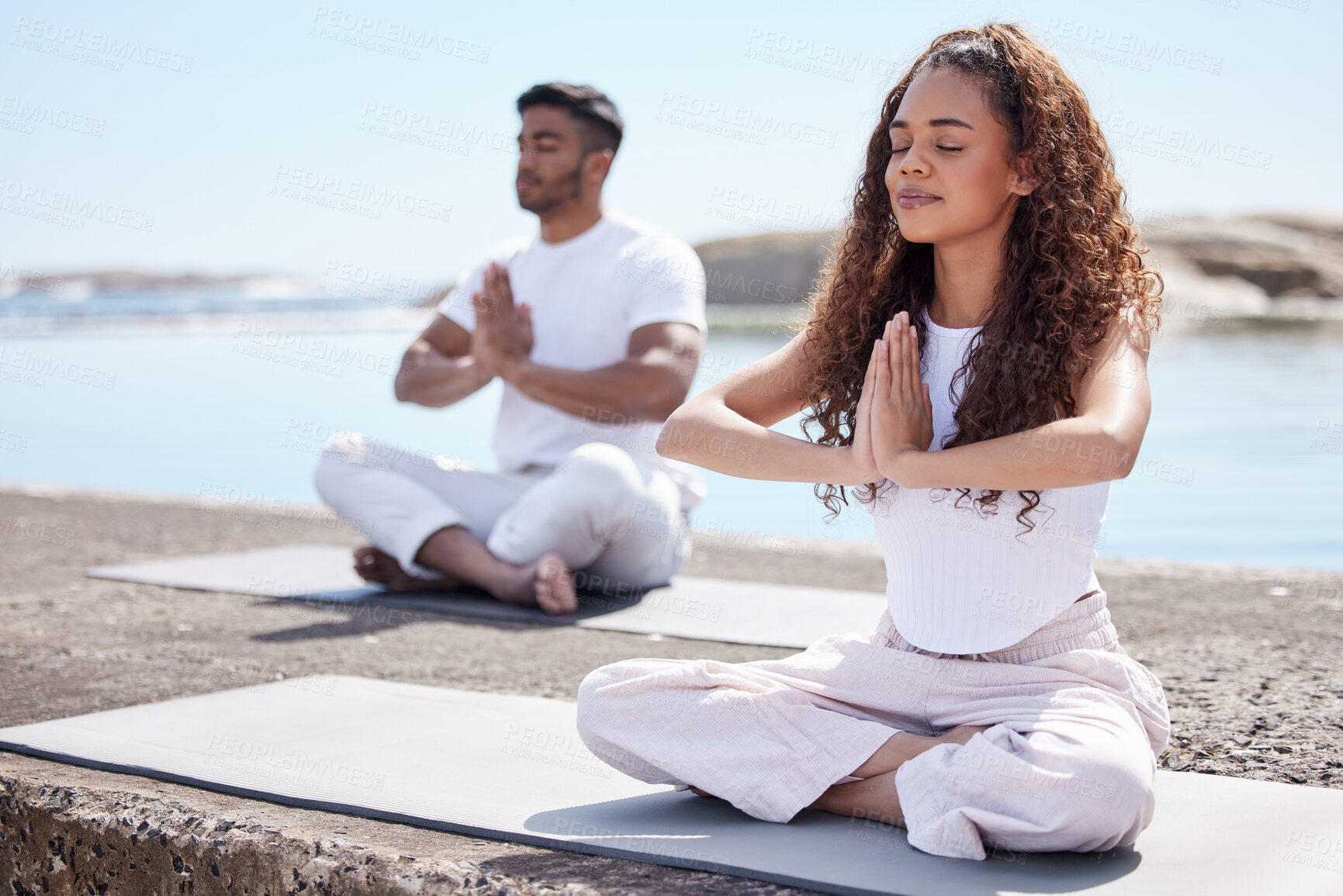 Buy stock photo Couple, yoga and ocean with namaste, peace and zen gesture with meditation and wellness outdoor. Nature, healthy people and smile with holistic and spiritual practice by the sea on a beach rock