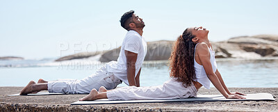 Buy stock photo Full length shot of a young couple practicing yoga at the beach