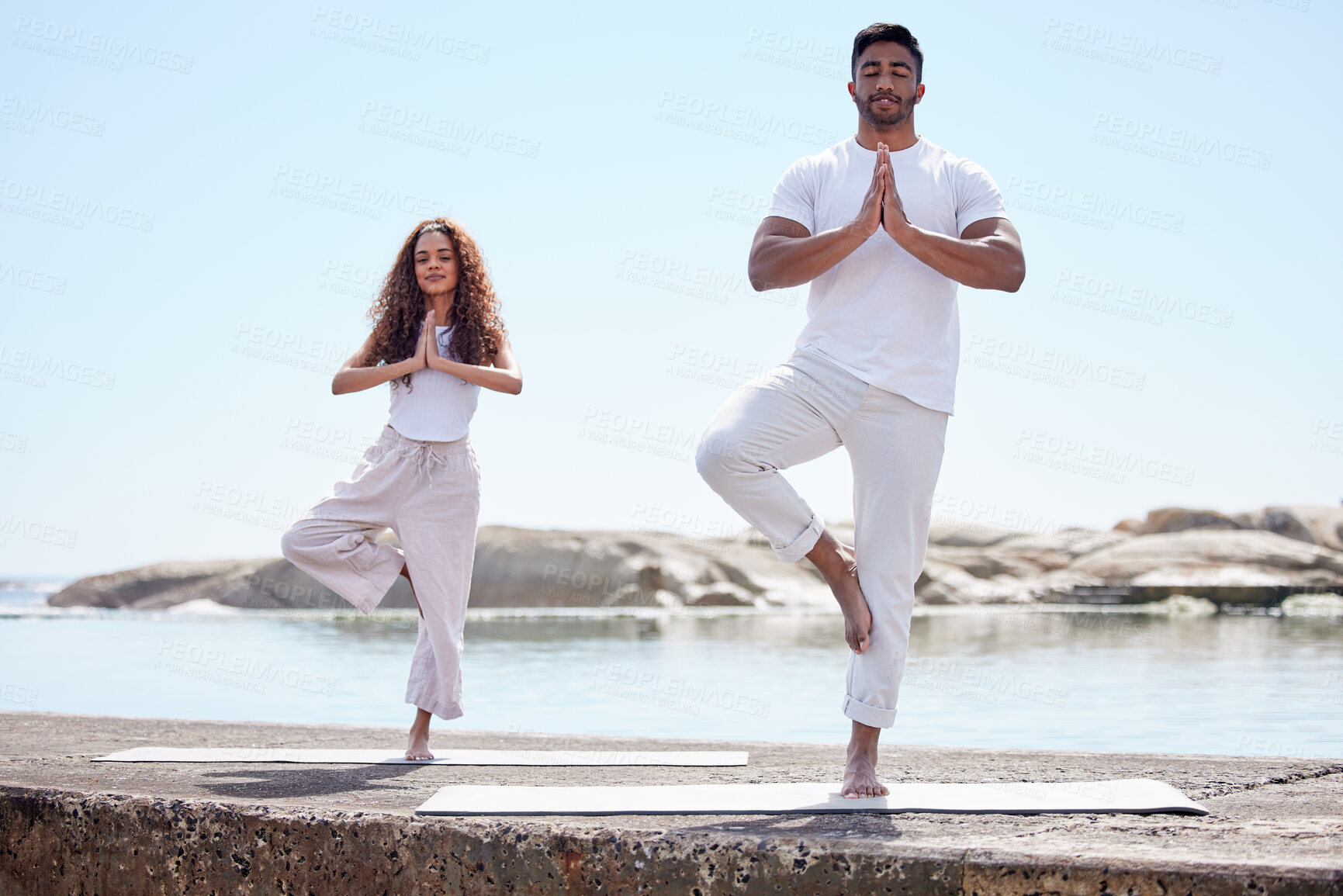 Buy stock photo Yoga, prayer hands and couple with meditation by ocean for spiritual fitness, mental wellness and namaste. Outdoor, pilates and yogi people with eyes closed for mindfulness, balance or tree pose