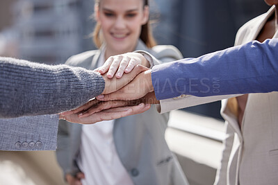 Buy stock photo Shot of a group of unrecognizable businesspeople stacking their hands together outside