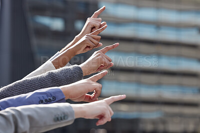 Buy stock photo Shot of a group of unrecognizable businesspeople pointing in the same direction together outside